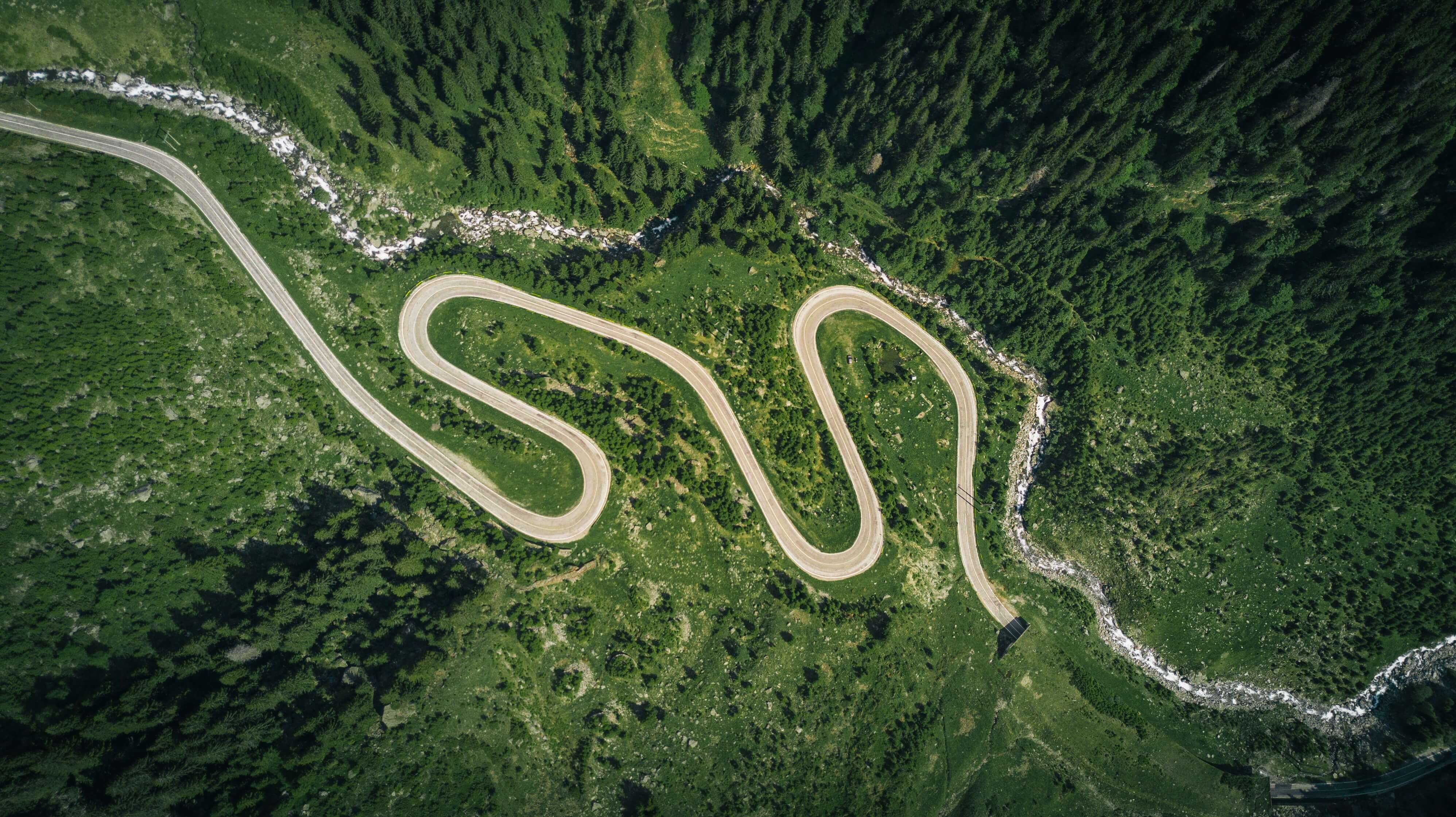 Aerial view of asphalt road surrounded by trees