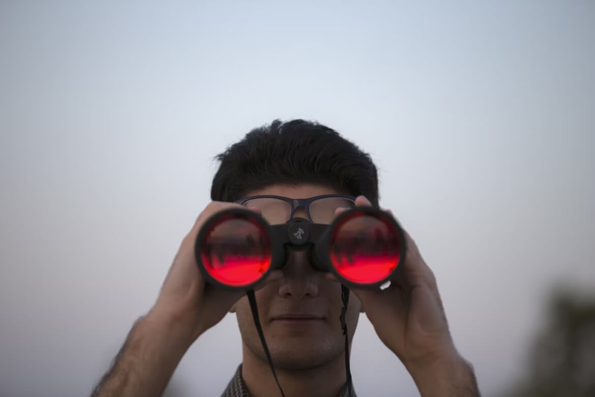Person holding black binoculars
